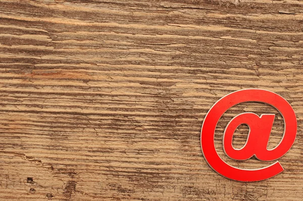 Красный символ электронной почты на деревянном фоне с копировальным пространством — стоковое фото