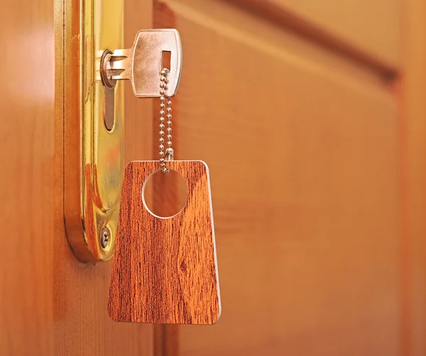 Key in keyhole with blank label — Stock Photo, Image