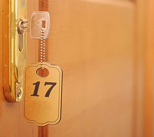 Key in keyhole with numbered label — Stock Photo, Image
