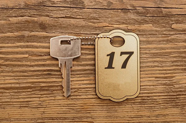 Снимок ключа от гостиничного номера на деревянном фоне — стоковое фото