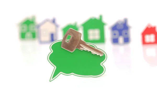 Bubble speech and silver key over the houses background — Stock Photo, Image