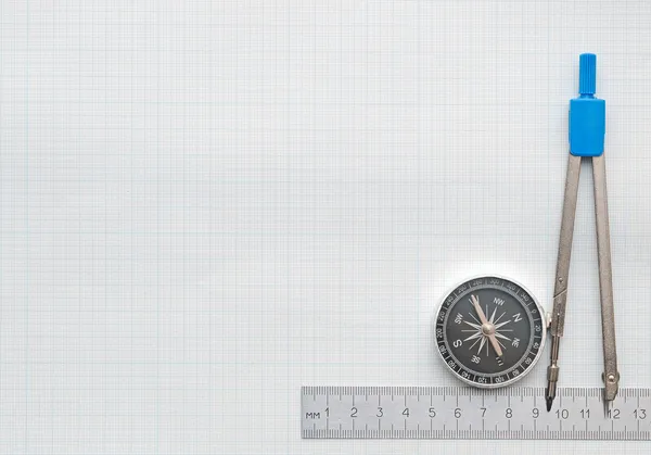 Compass and pencil on graph paper — Stock Photo, Image