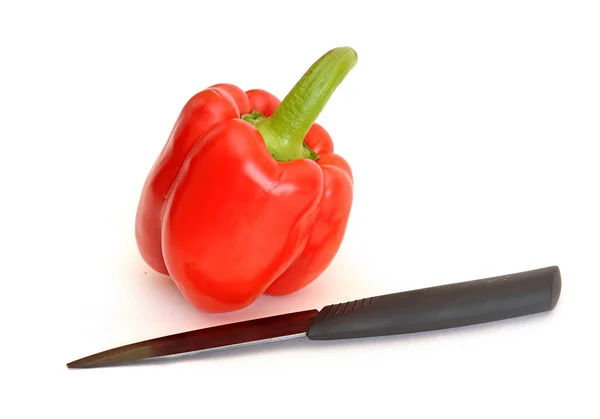 Red pepper with a knife on white background — Stock Photo, Image