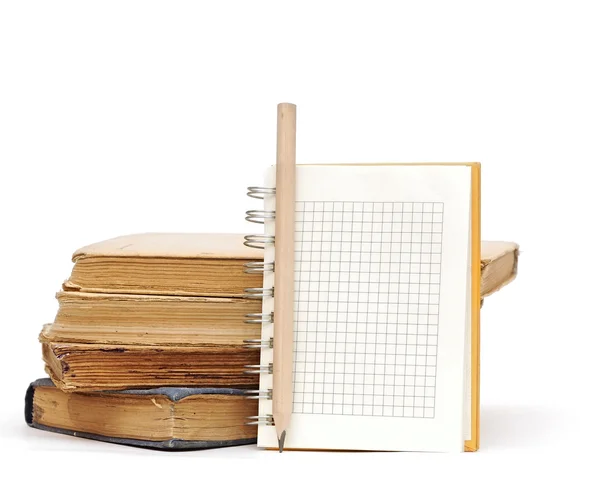 Pencil on notebook near pile of books on white — Stock Photo, Image