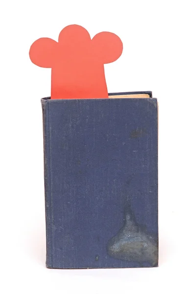 Paper shape chef hat on old book — Stock Photo, Image