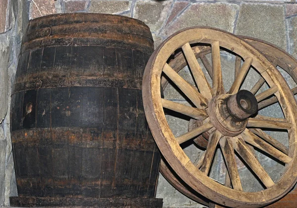 Wooden wagon wheel and barrel — Stock Photo, Image