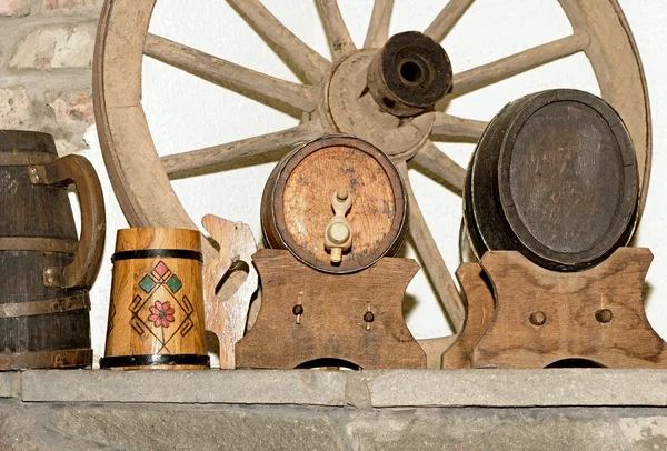Wooden wagon wheel and antique wooden small draught beer keg — Stock Photo, Image