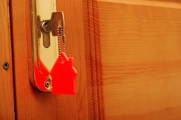 Символ дома и вставить ключ в замочную скважину — стоковое фото