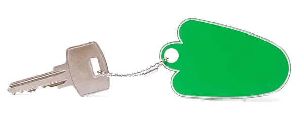 Una etiqueta verde en blanco con llave plateada sobre fondo blanco — Foto de Stock