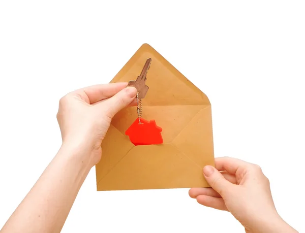 A woman's hand gets out of an envelope key with house symbol — Stock Photo, Image