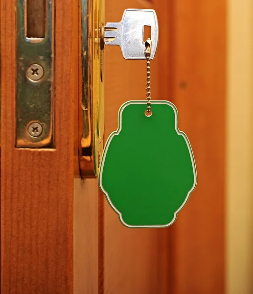 Schlüssel im Schlüsselloch mit leerem Etikett — Stockfoto