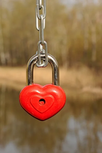 Red heart-shaped lock on the fence — Stock Photo, Image