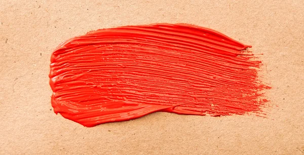 Red paint drawn with brush stroke on recycle paper — Stock Photo, Image