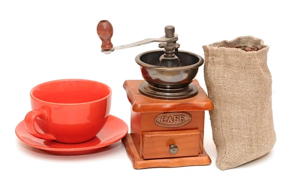 Tasse rouge avec grains de café et vieux moulin à café — Photo