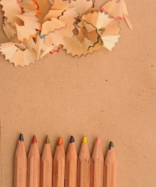 Colorful pencils with wooden shaving on recycle paper — Stock Photo, Image