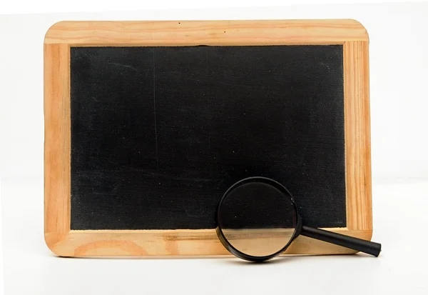 Blackboard with magnifying glass on white — Stock Photo, Image
