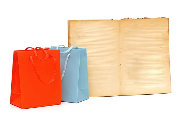 Shopping bags and blank old book on white background — Stock Photo, Image