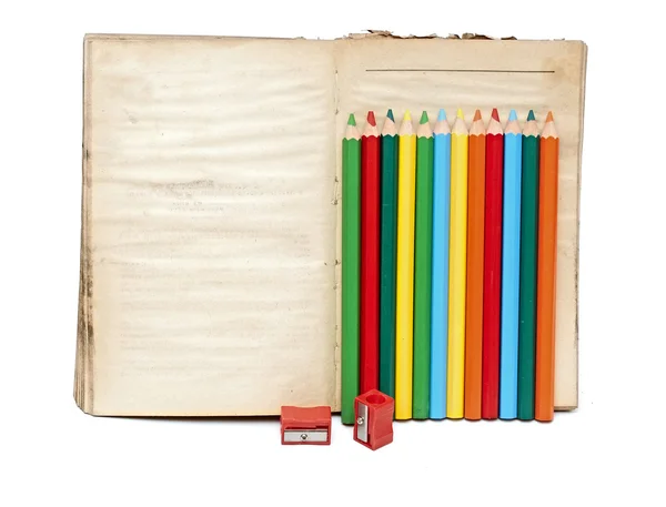 Matite di colore in legno e vecchio libro su sfondo bianco — Foto Stock