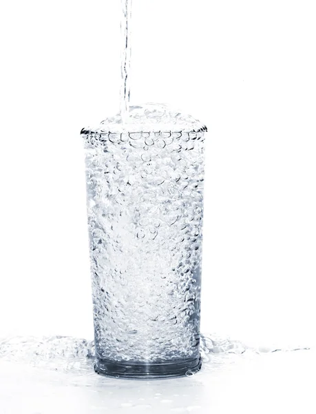 Pouring water into the glass isolated on a white background — Stock Photo, Image
