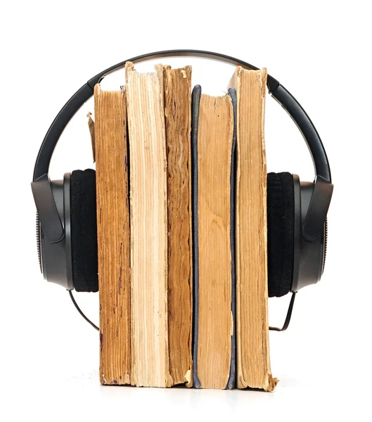 Słuchawki wokół książki sugeruje, słuchanie książek zamiast — Zdjęcie stockowe