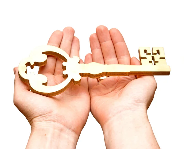 Золотой ключ в руках человека на белом фоне — стоковое фото