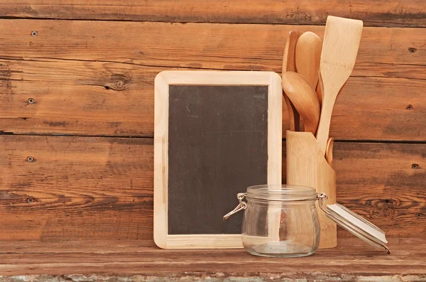 Blank blackboard on wooden surface and wooden utensils — Stock Photo, Image