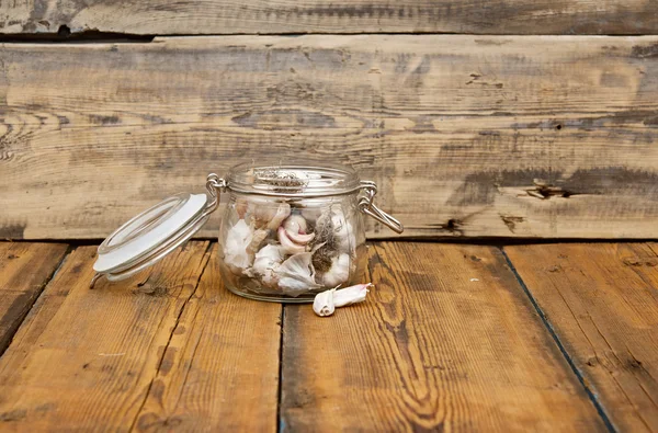 Ail frais dans un bocal en verre sur une vieille table en bois — Photo