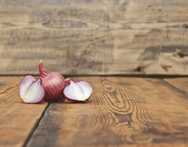 Cebola em fatias vermelhas na velha mesa de madeira — Fotografia de Stock