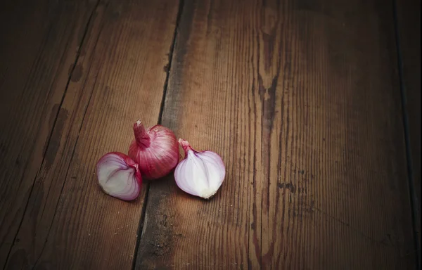 Eski ahşap masa üstünde kırmızı dilimlenmiş soğan — Stok fotoğraf