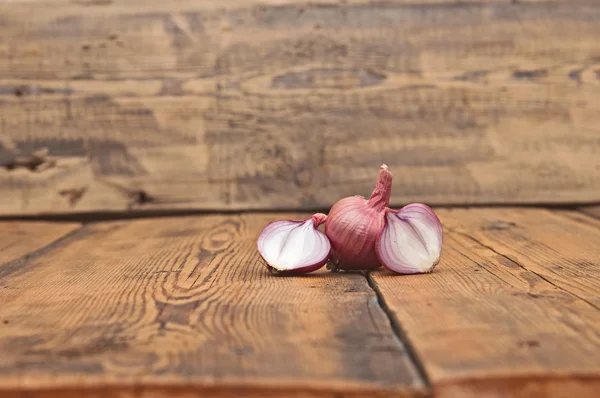 Cebola em fatias vermelhas na velha mesa de madeira — Fotografia de Stock