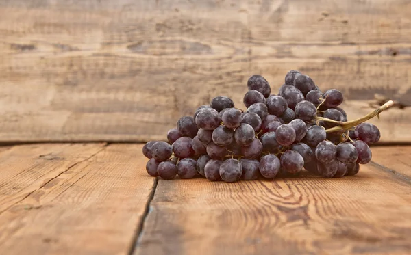 Raisins noirs sur une vieille table en bois — Photo