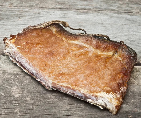 Morceaux de poisson fumé sur une vieille table en bois — Photo