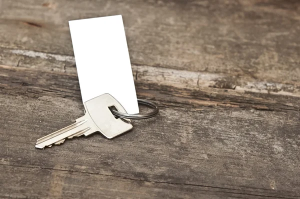 Schlüssel mit leerem Etikett auf einem alten Holztisch — Stockfoto