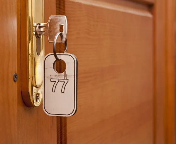 Πόμολα σε ξύλο πτέρυγα της πόρτας και το κλειδί στην κλειδαρότρυπα με αριθμό — Φωτογραφία Αρχείου