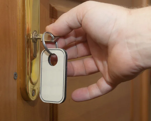 フロント ドアのロックを解除するキーを持つ手します。 — ストック写真
