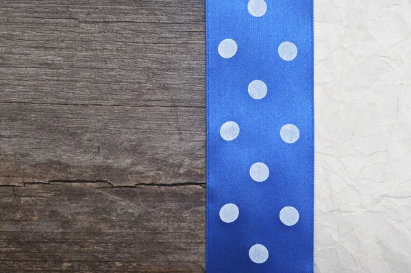 Fundo de madeira com fita azul polka-dot em papel amassado — Fotografia de Stock