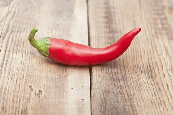 Red chili pepper on old wooden table — Stock Photo, Image