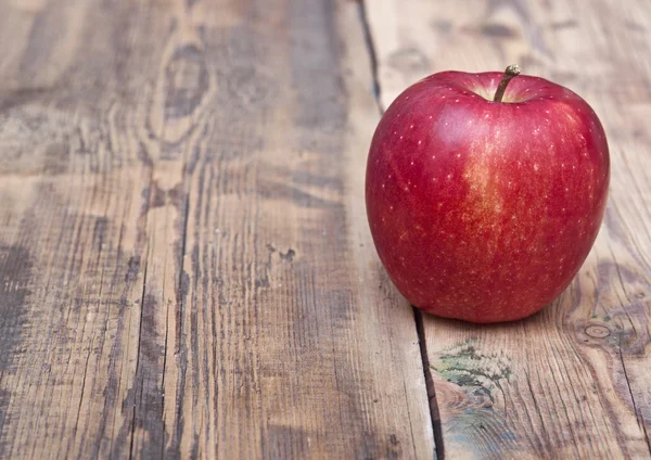 Rött äpple på gamla träbord — Stockfoto