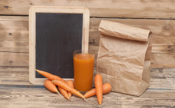 Comida saludable - zanahorias y jugo de zanahorias con pizarra en blanco f —  Fotos de Stock