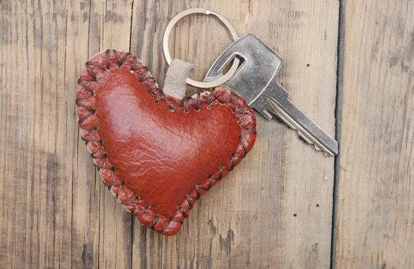 Sleutel met lederen trinket op houten achtergrond — Stockfoto