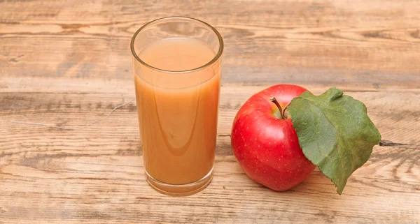 Apple with apple juice on a wooden background — Stock Photo, Image