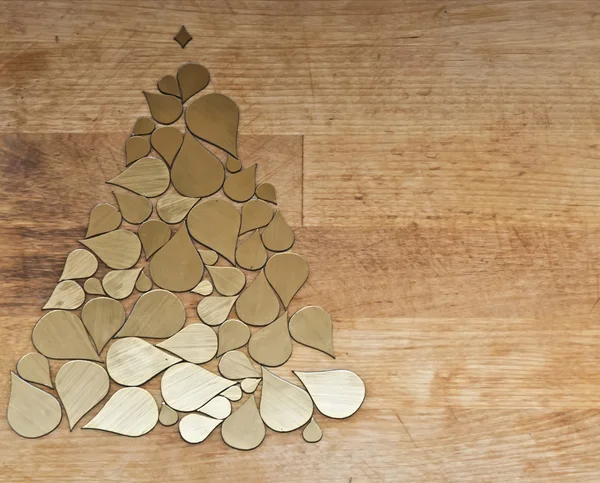 Árbol de Navidad hecho de elementos de gotas doradas sobre fondo de madera — Foto de Stock