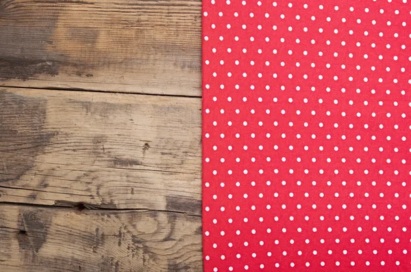 Leerer Holzdecktisch mit roter Tischdecke mit Tupfen — Stockfoto
