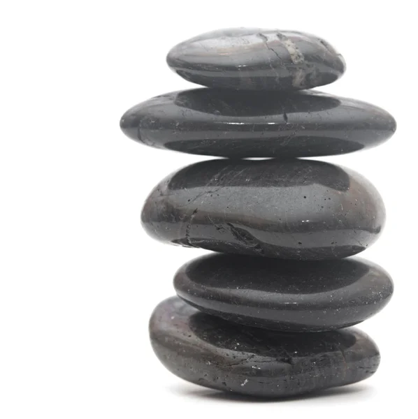 Masaż czarne kamienie ułożone, na białym tle — Zdjęcie stockowe