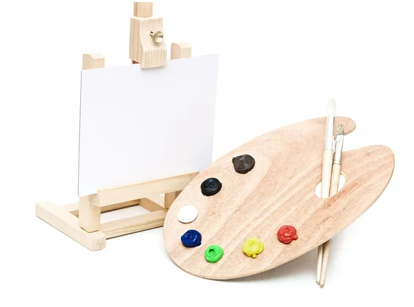 Cavalete de madeira com papel limpo e paleta de artistas de madeira carregada — Fotografia de Stock
