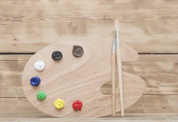 Paleta de arte de madera con pintura y pinceles sobre fondo de madera —  Fotos de Stock