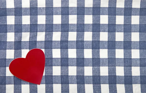 Rote Herzform auf kariertem Textilhintergrund — Stockfoto
