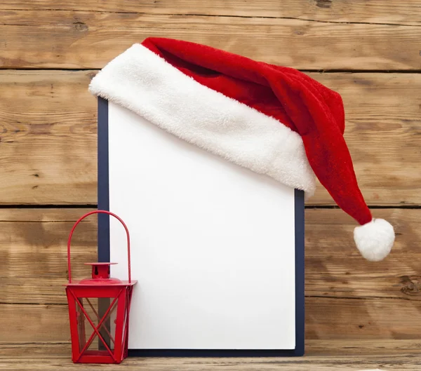 Santa hat on clipboard with blank sheet of paper for your text — Stock Photo, Image