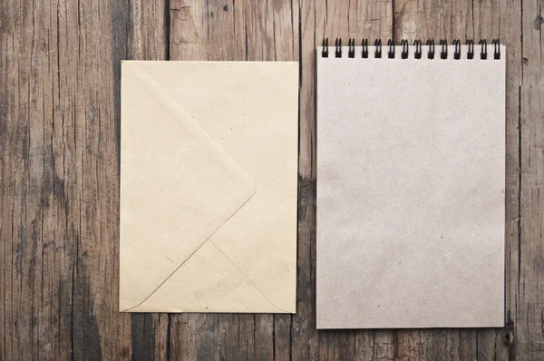 Brun blank anteckningsbok och kuvert på grunge trä — Stockfoto