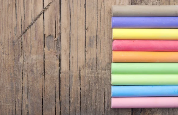 Colorful chalks on old wooden table — Stock Photo, Image